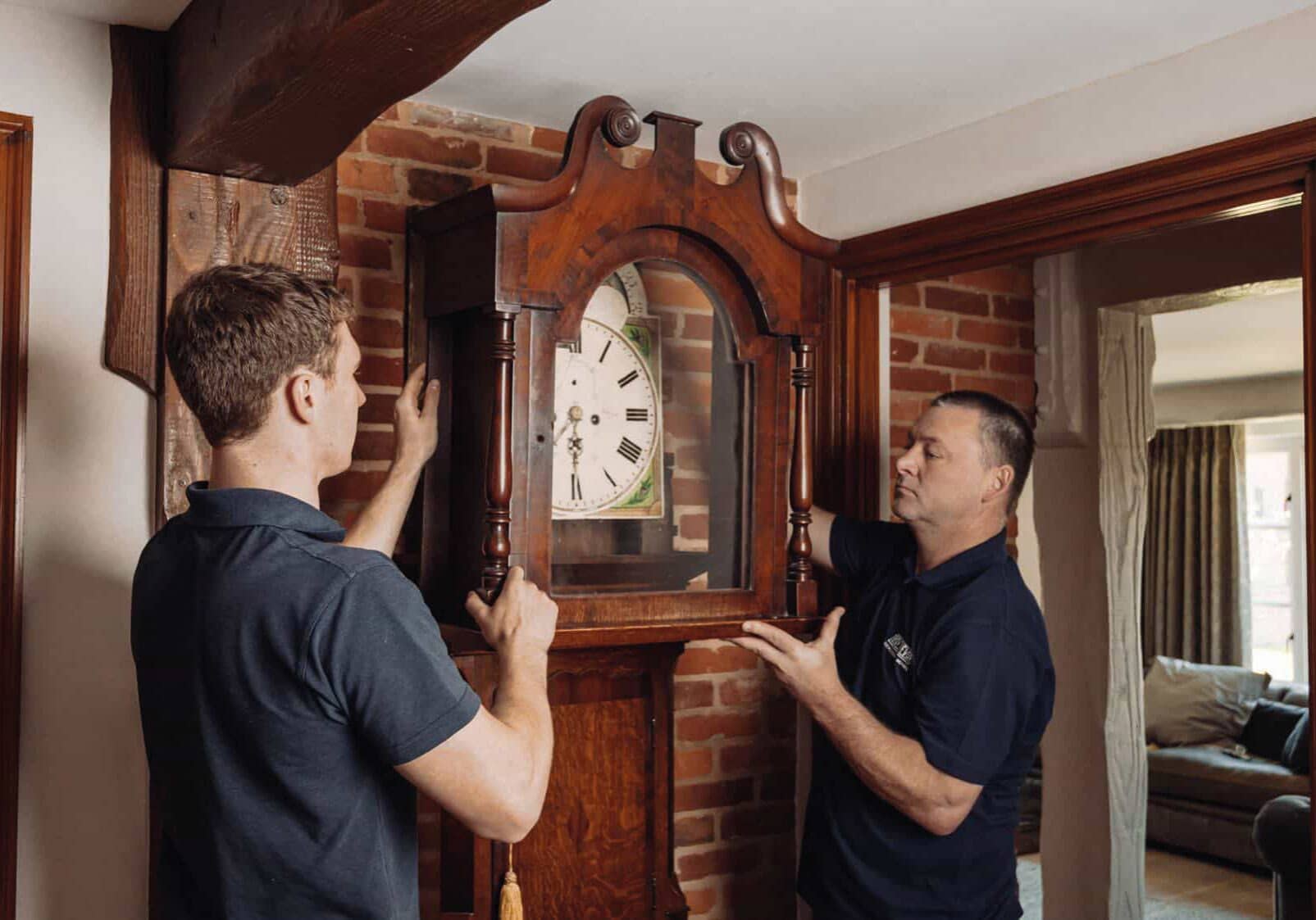Roy Trevor team moving a grandfather clock