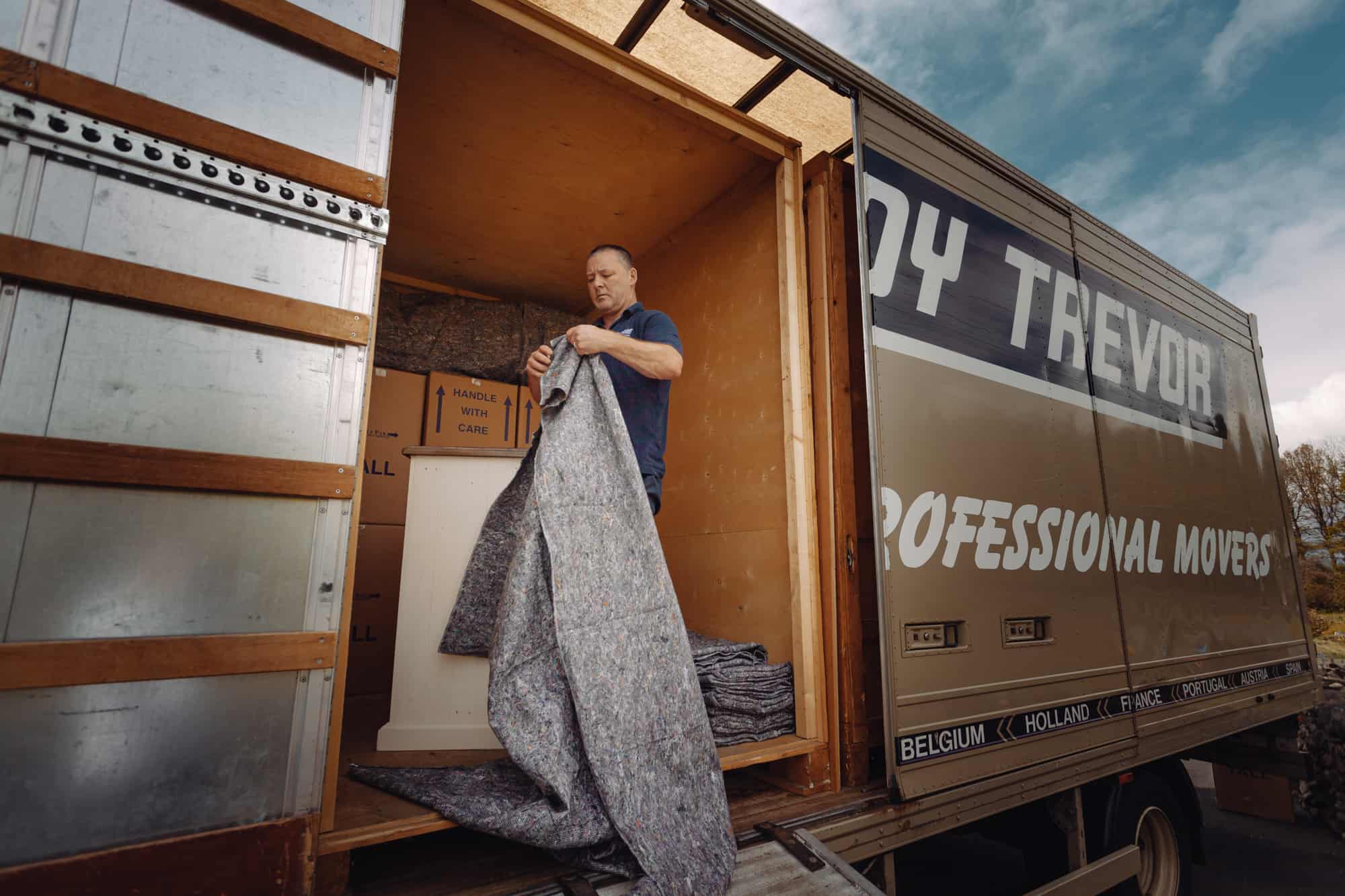 man using packing blankets in lorry