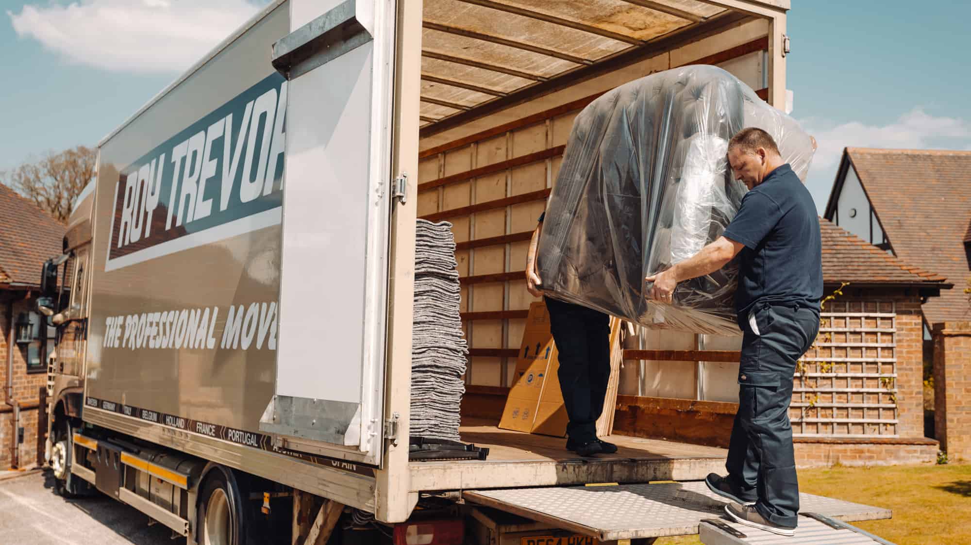 two men moving a sofa into a van